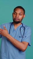 Vertical Male nurse holding IV bag, preparing to use it to administer fluids, medications and nutrients directly into patient veins, studio background. Man holding intravenous therapy medical tool, camera B video