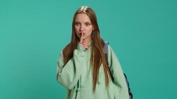 Stern woman doing shushing hand gesturing, irritated by noise, having negative mood. Girl placing finger on lips, doing quiet sign gesture, isolated over studio background, camera A video