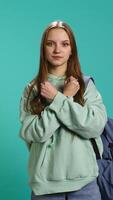 Vertical Assertive woman shows letter X with arms crossed, staying in warrior stance, showing fierceness. Firm young person using negative body language to signal rejection, studio background, camera B video