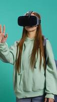 Vertical Woman wearing virtual reality headset, doing swiping gestures. Technology enthusiast using high tech futuristic modern VR gadget, isolated over studio background, camera B video