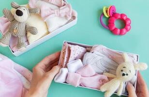 Women's hands collect children's clothes into boxes. photo