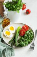 Fresh Spring Salad With Boiled Eggs, Asparagus, and Tomatoes on a Bright Day photo