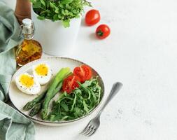 Fresh Spring Salad With Boiled Eggs, Asparagus, and Tomatoes on a Bright Day photo