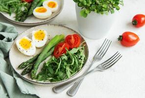 Fresh Spring Salad With Boiled Eggs, Asparagus, and Tomatoes on a Bright Day photo
