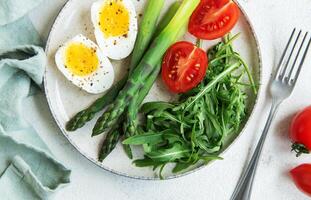 Fresh Spring Salad With Boiled Eggs, Asparagus, and Tomatoes on a Bright Day photo