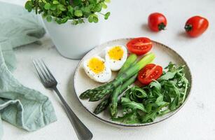 Fresh Spring Salad With Boiled Eggs, Asparagus, and Tomatoes on a Bright Day photo