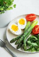 Fresh Spring Salad With Boiled Eggs, Asparagus, and Tomatoes on a Bright Day photo