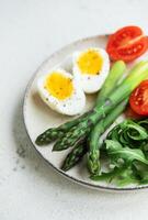 Fresh Spring Salad With Boiled Eggs, Asparagus, and Tomatoes on a Bright Day photo