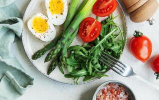 Fresh Spring Salad With Boiled Eggs, Asparagus, and Tomatoes on a Bright Day photo