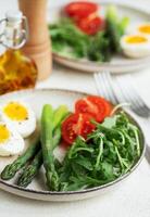 Fresh Spring Salad With Boiled Eggs, Asparagus, and Tomatoes on a Bright Day photo