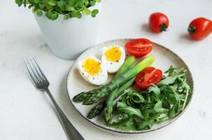 Fresh Spring Salad With Boiled Eggs, Asparagus, and Tomatoes on a Bright Day photo