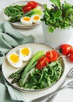Fresh Spring Salad With Boiled Eggs, Asparagus, and Tomatoes on a Bright Day photo