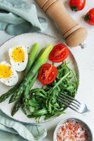 Fresh Spring Salad With Boiled Eggs, Asparagus, and Tomatoes on a Bright Day photo