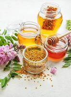 Raw organic bee pollen and honey in jars. photo