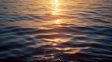 The calming stillness of the water mirroring the serene hues of the sunset broken only by the faint sounds of seagulls and boats in the distance photo