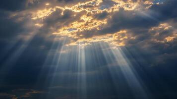 The suns rays shine through a layer of stormy nimbostratus clouds photo
