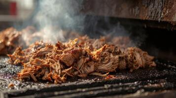 Tender chunks of pulled pork emerge from the fiery depths of the pit their savory aroma filling the air. Soon they will complete their journey to the plate where they wil photo