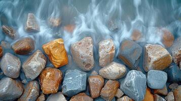 Closeup of a rocky shoreline capturing the varying textures of smooth jagged and weathered stones that have been shaped by the constant motion of the ocean photo