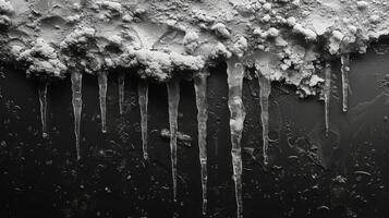 Texture of melting icicles dripping down from a rooftop revealing a mix of rough and smooth surfaces as they transition from solid to liquid photo
