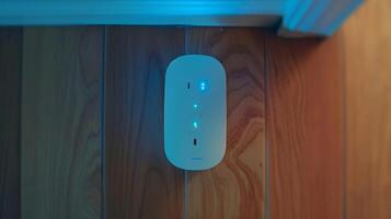 A topdown view of a smart plug with a subtle blue light illuminated indicating that it is connected to a WiFi network and ready to be controlled remotely photo
