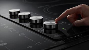 A finger pressing the power button on an induction cooktop surrounded by digital temperature controls photo