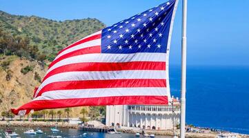americano estrella adornado con lentejuelas bandera ondulación en California. un grande americano bandera es volador alto encima foto