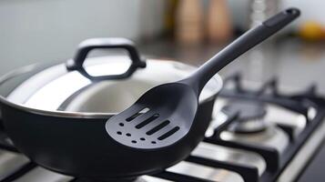 A detailed image of the stirring spatula specially designed to fit through the lid and evenly distribute heat for consistent results photo
