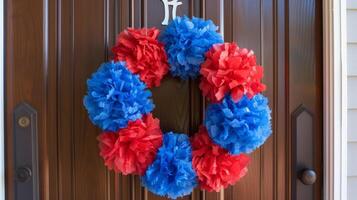 A festive wreath made out of red white and blue crepe paper hanging on a front door to welcome guests for a Fourth of July party photo