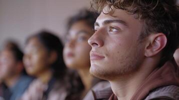 A closeup of a students face as they listen intently to their professor surrounded by other focused students of different nationalities in a comfortable and inviting classroo photo