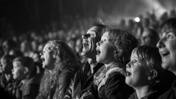 The crowd is fully engrossed in the show with wideeyed children sitting on their parents shoulders and older folks tapping their feet to the lively music. The atmosphere i photo