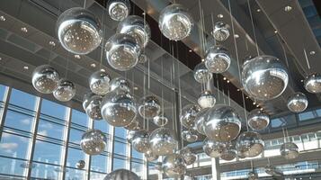 Hanging from the ceiling in the main terminal a massive mobile made of silver orbs dances and rotates with the gentle breeze creating a mesmerizing display for passengers photo