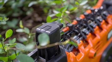 A closeup of the safety guard on an electric hedge trimmer protecting fingers from the sharp blades photo