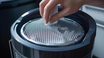 A humidifiers filter being removed for cleaning revealing a mesh pattern that s impurities and dust particles photo
