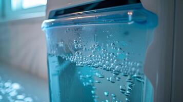 The water tank of a dehumidifier being emptied and cleaned to prevent buildup of bacteria and mold photo