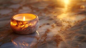 The warm golden light of a candle flame juxtaposed against the cool marble surface of a candle warmer creating a striking contrast photo