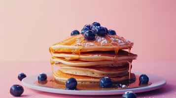 A stack of fluffy pancakes drizzled with sticky syrup and dotted with fresh blueberries providing a mouthwatering start to the day photo