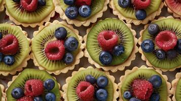 A tray of bitesized fruit tarts each one topped with a perfectly p kiwi slice raspberry or blueberry showcasing the vibrant colors and fresh flavors of the season photo