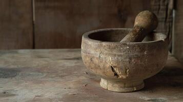 A closeup of an old wooden mortar and pestle worn smooth from years of grinding various plants and herbs for medicinal purposes photo