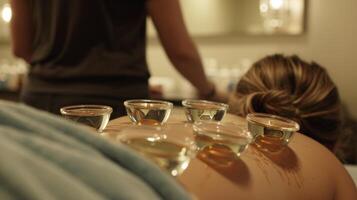 A cupping session in progress showing multiple glass cups suctioned onto the clients back photo