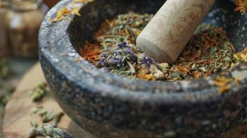 A mortar and pestle grinding together a selection of dried herbs. This traditional od of preparing herbs for remedies dates back centuries grinding and mixing herbs to creat photo