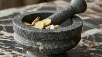 A mortar and pestle grinding up fresh ginger root an essential ingredient in many Chinese remedies for its antiinflammatory and digestive benefits photo