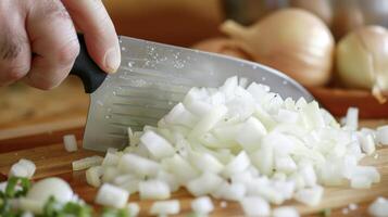 A person is actively chopping onions on a wooden cutting board photo