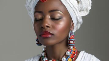 The simplicity of a black womans white garment is offset by the intricate beading and bold color accents adorning it. With closed eyes she exudes a sense of inner peace and connection photo