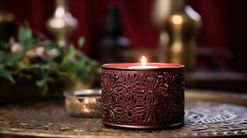 A vintage metal candle holder featuring intricate floral patterns, holding a rich burgundy candle that adds a pop of color to a neutral and rustic decor. photo