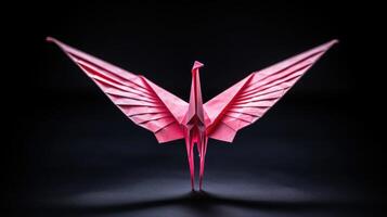 A tiny paper crane, wings spread open and body delicately folded to perfection, its vibrant pink color standing out against a dark background. photo