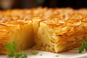 un tamaño bocado parte de patata kugel, exhibiendo el meticuloso arreglo de Delgado patata rebanadas, resultante en un visualmente atractivo en forma de mosaico modelo. foto