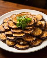 Crispy fried eggplant slices, drizzled with honey and sprinkled with sea salt. The eggplant is lightly breaded and fried to perfection, becoming tender and caramelized on the inside photo