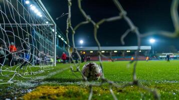 The silence is broken by the loud thud of the ball hitting the back of the net followed by a roar from the winning teams fans photo