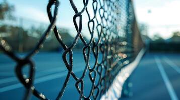 A closeup view of a tennis courts net partially obstructed by the blurred movement of a player swinging their racket photo