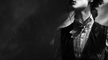 The contours of a womans face are shrouded in shadow adding a mysterious quality to the portrait. Her outfit is a mix of different textures with a lace blouse leather waistcoat and photo